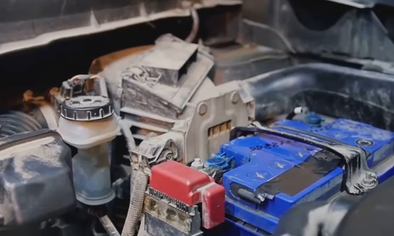 Plavi akumulator ispod haube auta